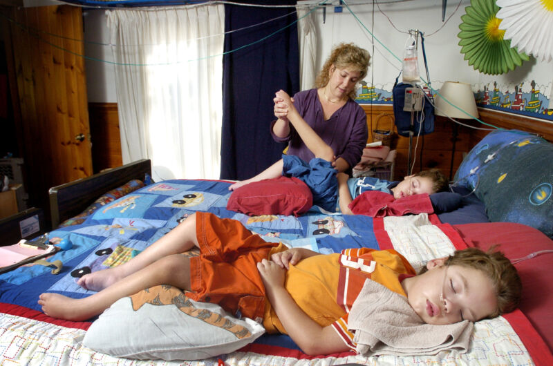 A mother with her twin 6-year-old boys who have metachromatic leukodystrophy, a genetic disease that leaves them unable to move. Photo taken on September 3, 2004.