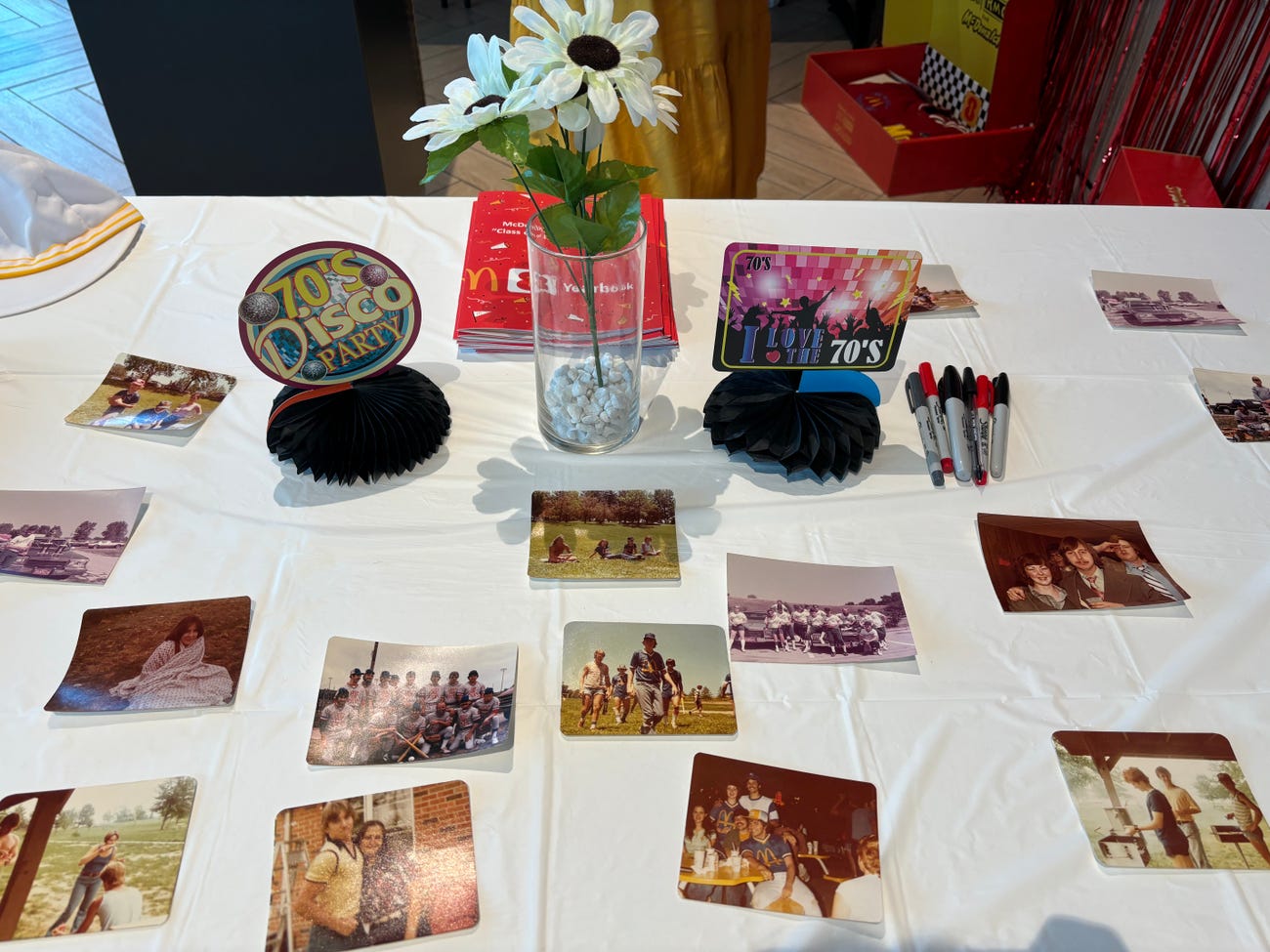 A table decorated with photos of former McDonald's workers and 70s items