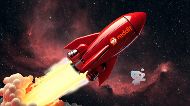 a red rocket with Reddit printed on the side shooting into space