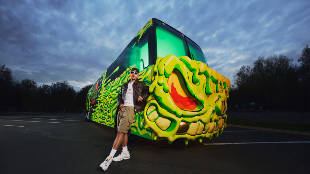 reggaeton superstar Feid leaning on his monstrous tour bus
