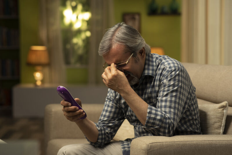 man watching TV, holding face