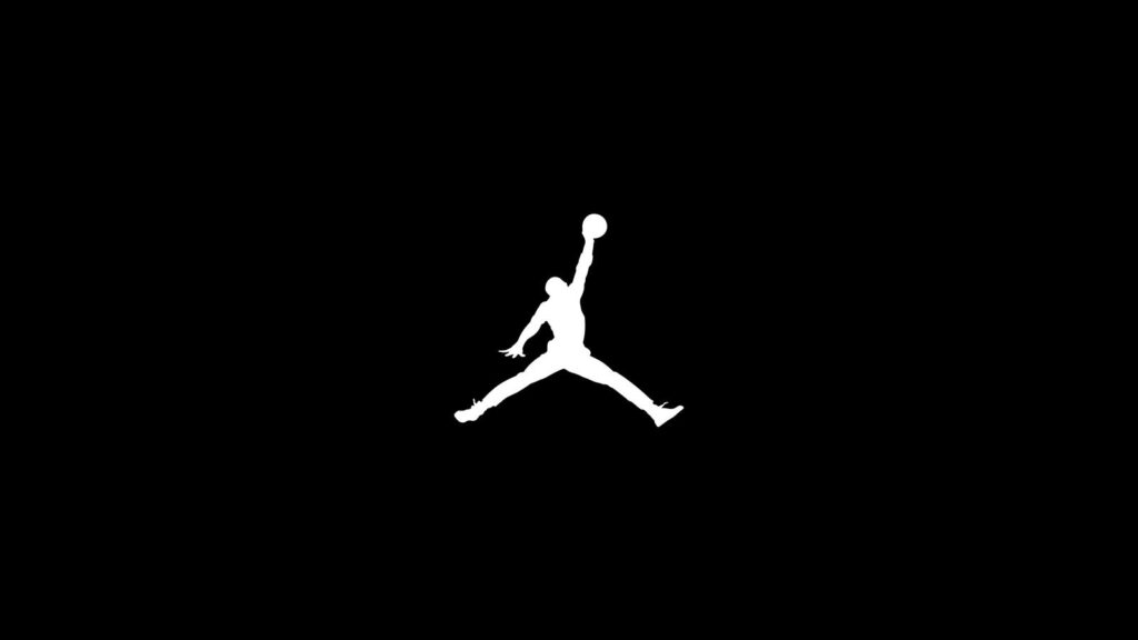 the air jordan logo in black and white of michael jordan jumping in the air holding a basketball