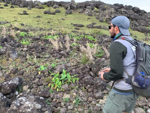 Binghamton University's Robert J. DiNapoli stands next to a rock garden on Rapa Nui, or Easter Island.