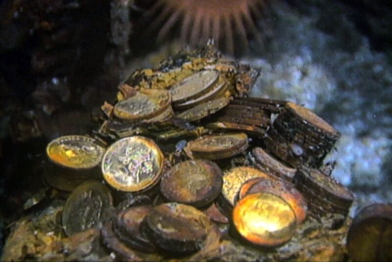 gold coins and gold bars scattered on the ocean floor