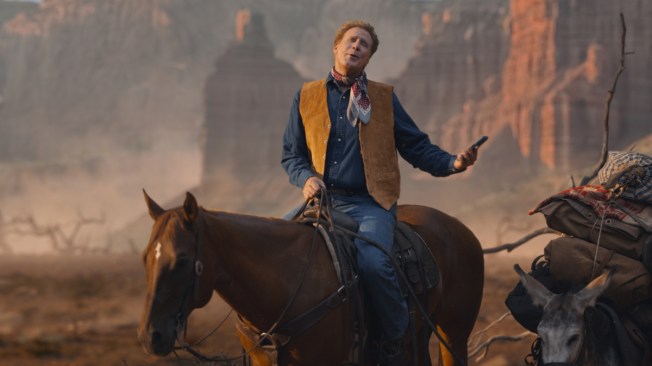 man on horse in western attire singing, holding a phone