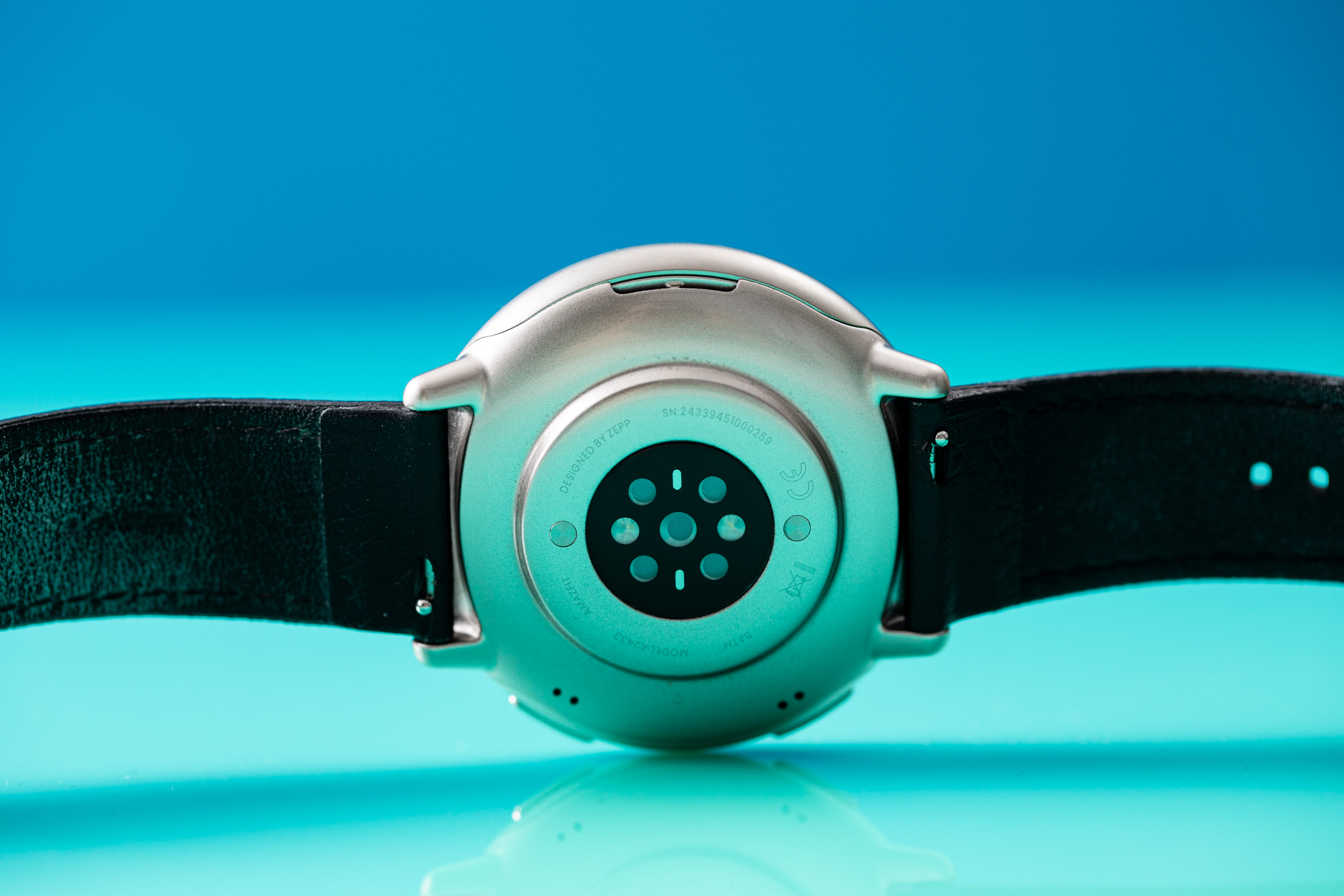 Wide-angle view of the Amazfit Active 2’s sensor array, which houses the health sensors. There’s a blue sheen due to the reflective acrylic surface it sits on top of.