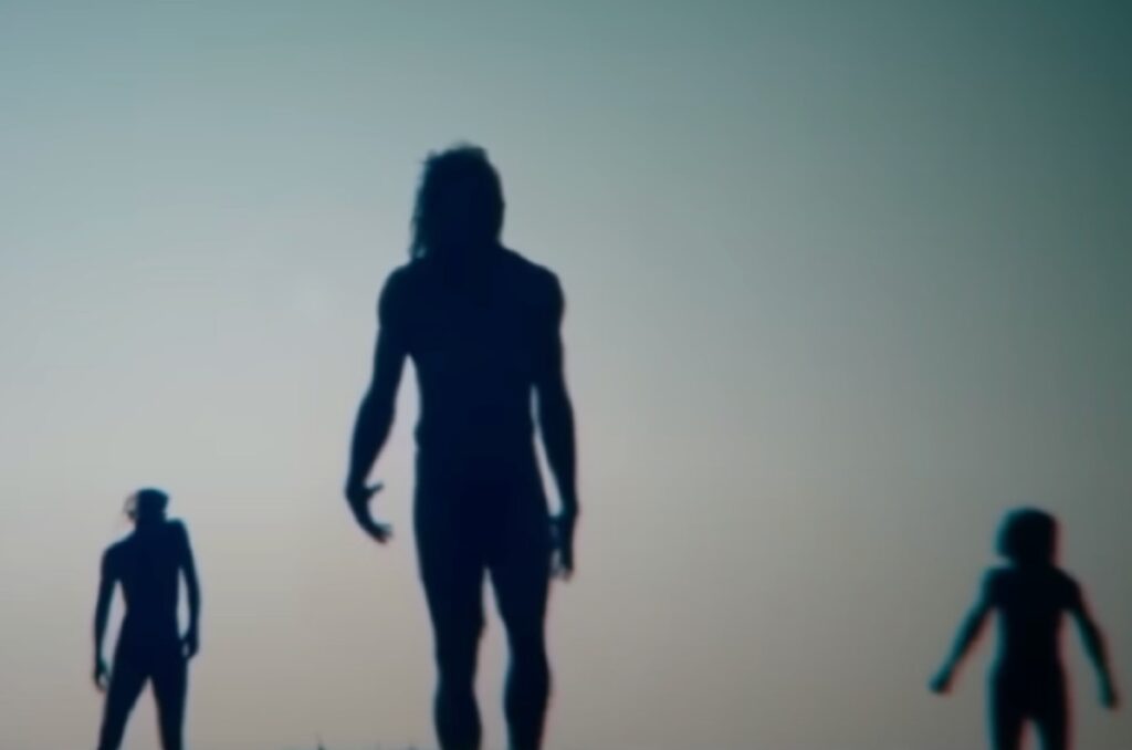 silhouette of three emaciated zombies on the horizon.