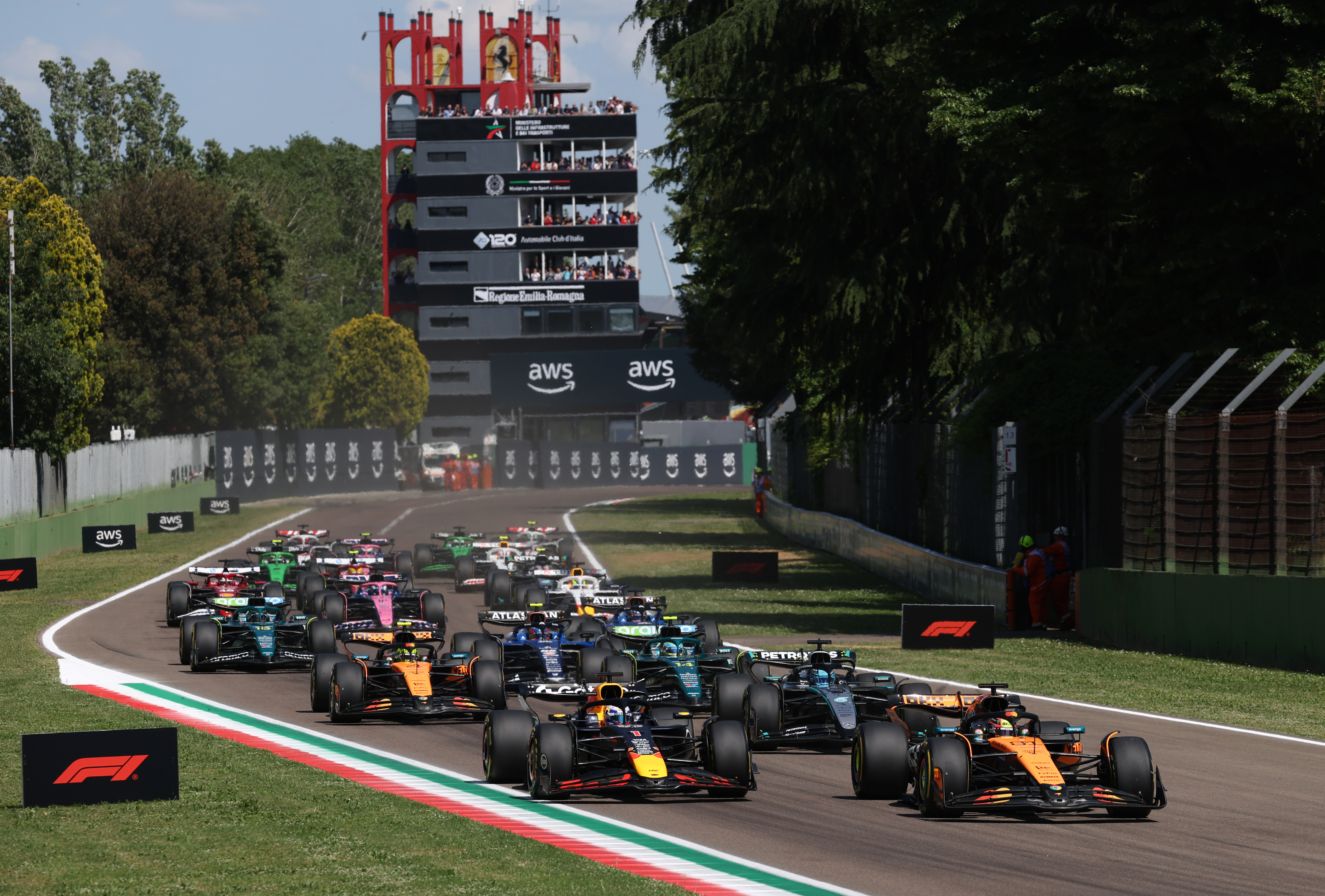 IMOLA, ITALY - MAY 18: Oscar Piastri of Australia driving the (81) McLaren MCL39 Mercedes leads Max Verstappen of the Netherlands driving the (1) Oracle Red Bull Racing RB21 George Russell of Great Britain driving the (63) Mercedes AMG Petronas F1 Team W16 Lando Norris of Great Britain driving the (4) McLaren MCL39 Mercedes Fernando Alonso of Spain driving the (14) Aston Martin F1 Team AMR25 Mercedes and the rest of the field at the start during the F1 Grand Prix of Emilia-Romagna at Autodromo Internazionale Enzo e Dino Ferrari on May 18, 2025 in Imola, Italy.