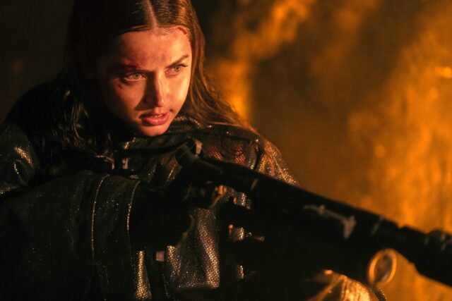 determined young woman holding a flame thrower.