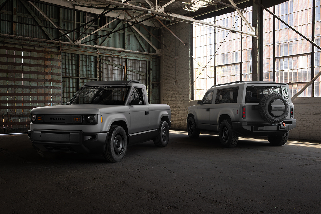Two cars indoors, with the one on the left facing the camera and the one on the right facing away.