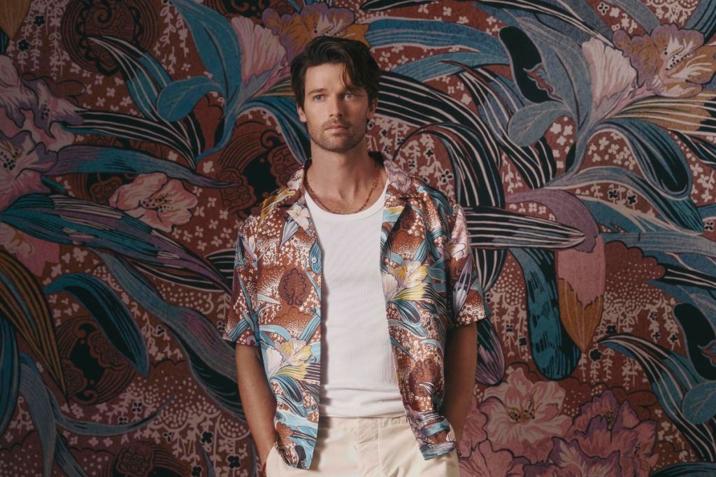 Actor Patrick Schwarzenegger wears tropical print shirt against tropical background