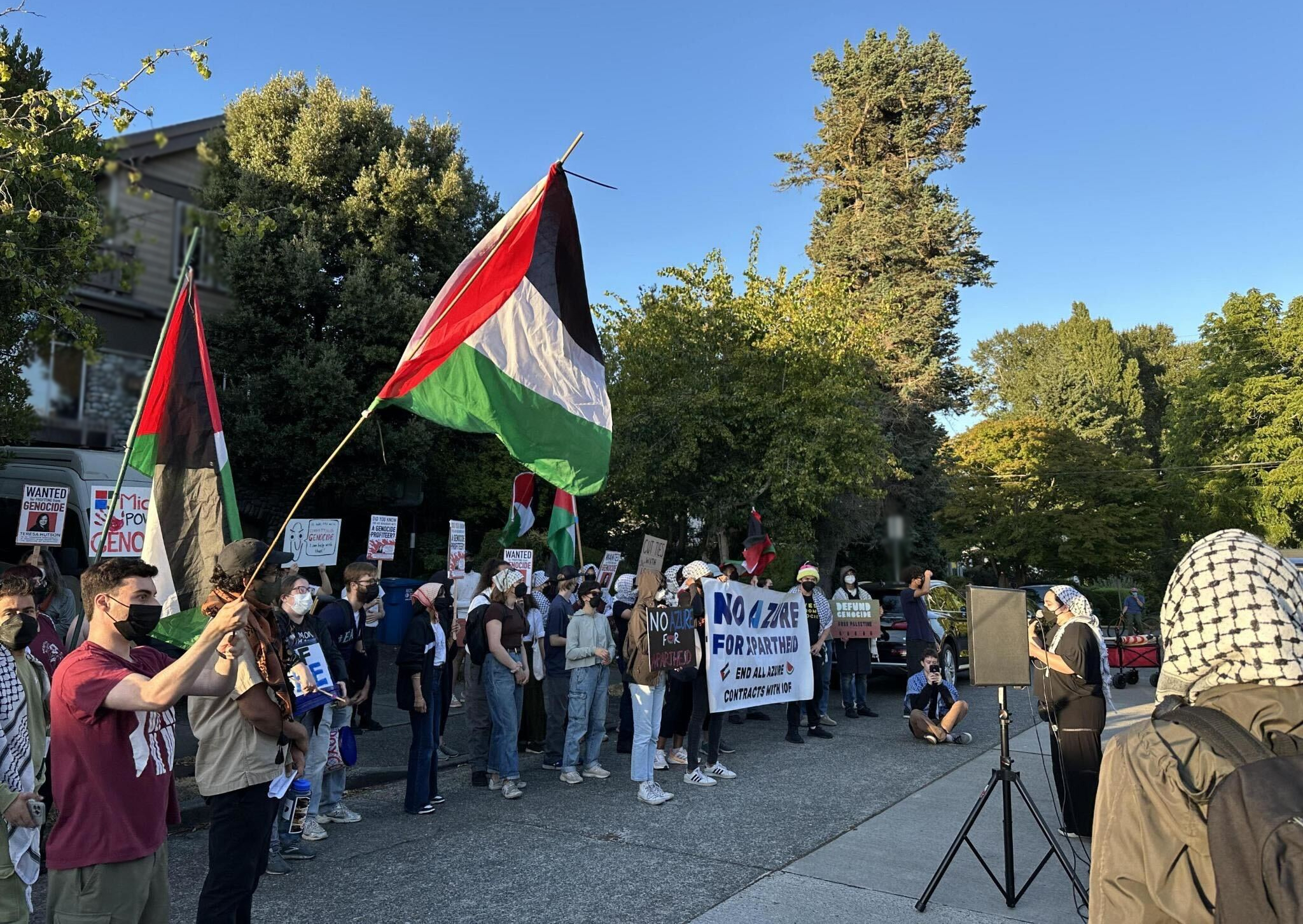 Protesters also carried wanted signs and banners (blurred to remove identifying details).