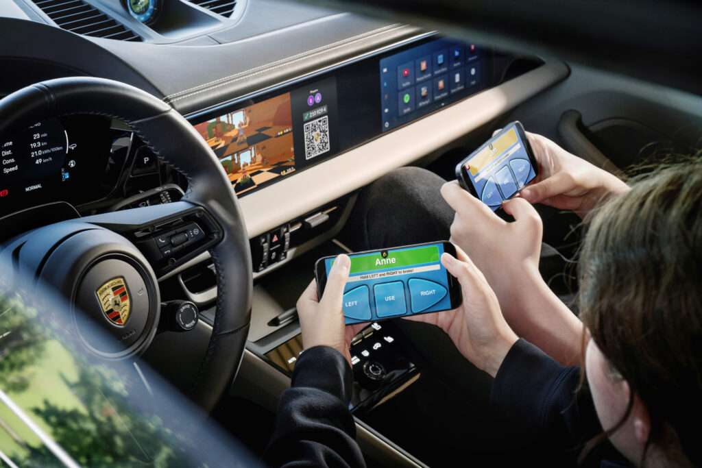Two people use their phones to play AirConsole inside a Porsche Macan