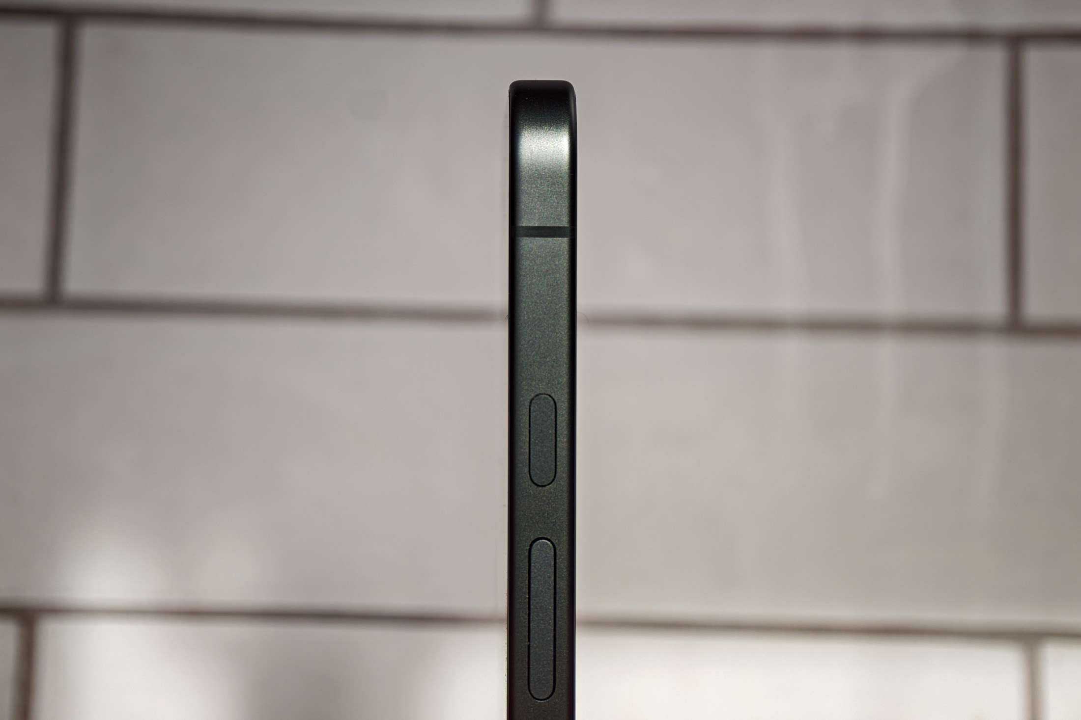 Photo of Google Pixel 10A in front of white tiles, shot from the side to show it’s totally flush