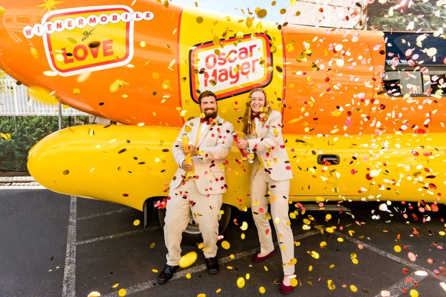Wedded hotdoggers in front of the Oscar Mayer Wienermobile