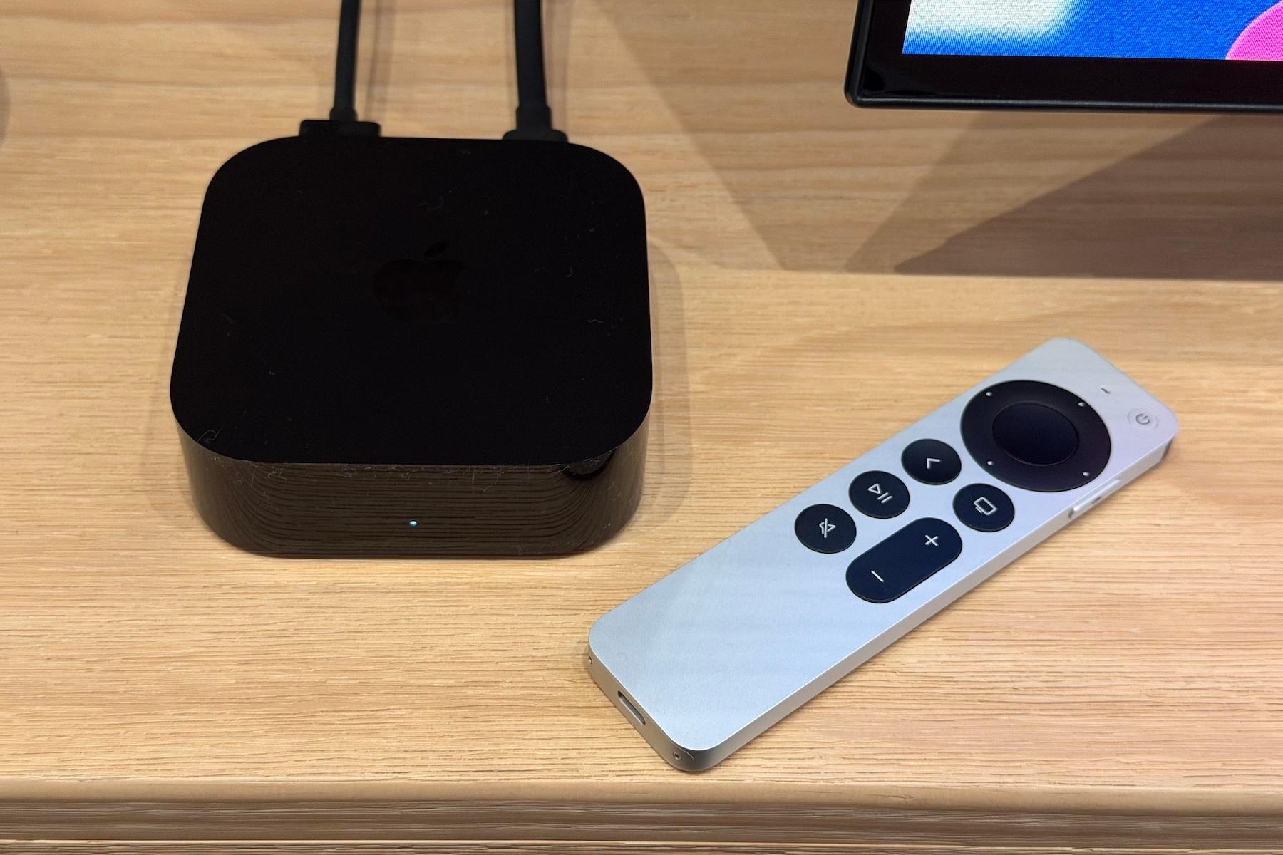The 4th-generation Apple TV 4K and its remote on a tan wooden table at the Apple Welcome Home event.